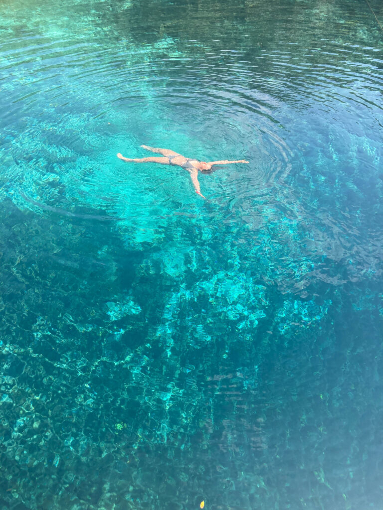 Anna en train de se baigner dans l'eau turquoise de la Cenote Corazon au Mexique