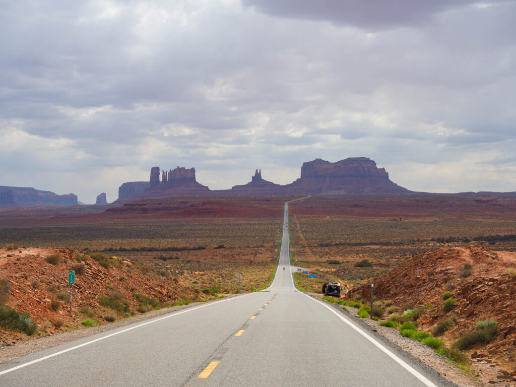 route dans le desert avec des roches au fond